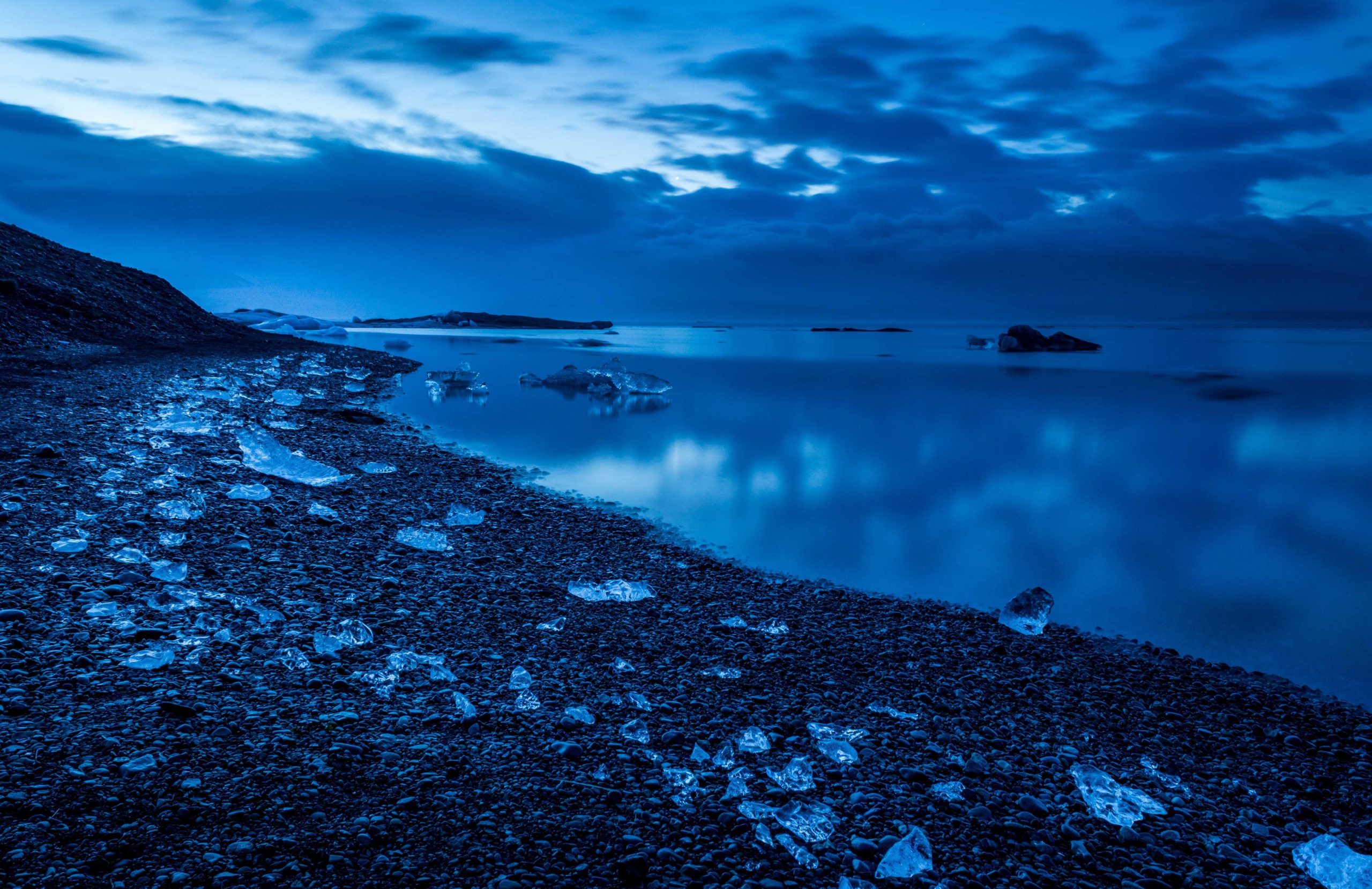 Vast blue sky stretching over open waters with soft clouds