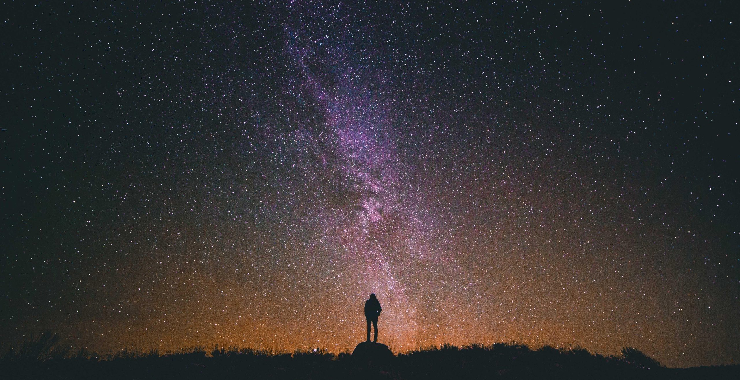 Night sky filled with stars above a silhouetted mountain range