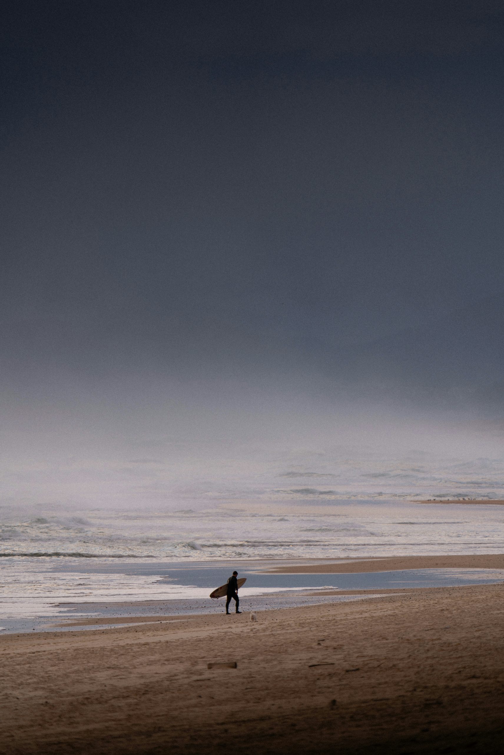 Serene Person Carrying A Surfboard